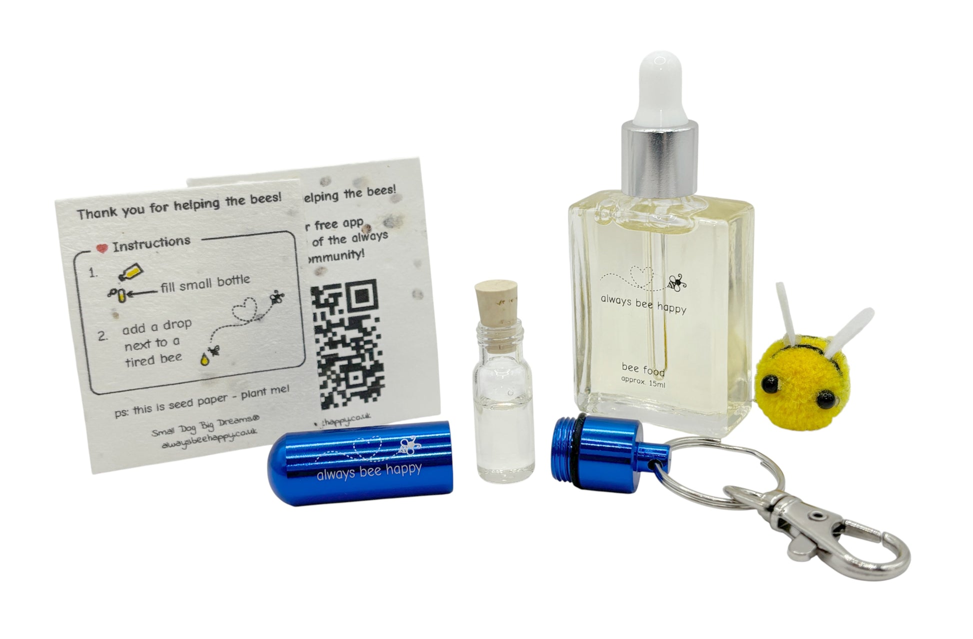 Bee revival kit including a 15ml bottle for top-ups, blue aluminium keychain with inner glass vial and premium cork, and instruction card on seed paper. And a fluffy bee of course.