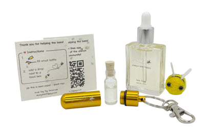 Bee revival kit including a 15ml bottle for top-ups, gold aluminium keychain with inner glass vial and premium cork, and instruction card on seed paper. And a fluffy bee of course.