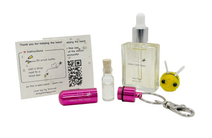 Bee revival kit including a 15ml bottle for top-ups, pink aluminium keychain with inner glass vial and premium cork, and instruction card on seed paper. And a fluffy bee of course.