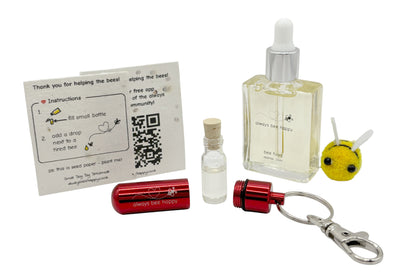 Bee revival kit including a 15ml bottle for top-ups, red aluminium keychain with inner glass vial and premium cork, and instruction card on seed paper. And a fluffy bee of course.