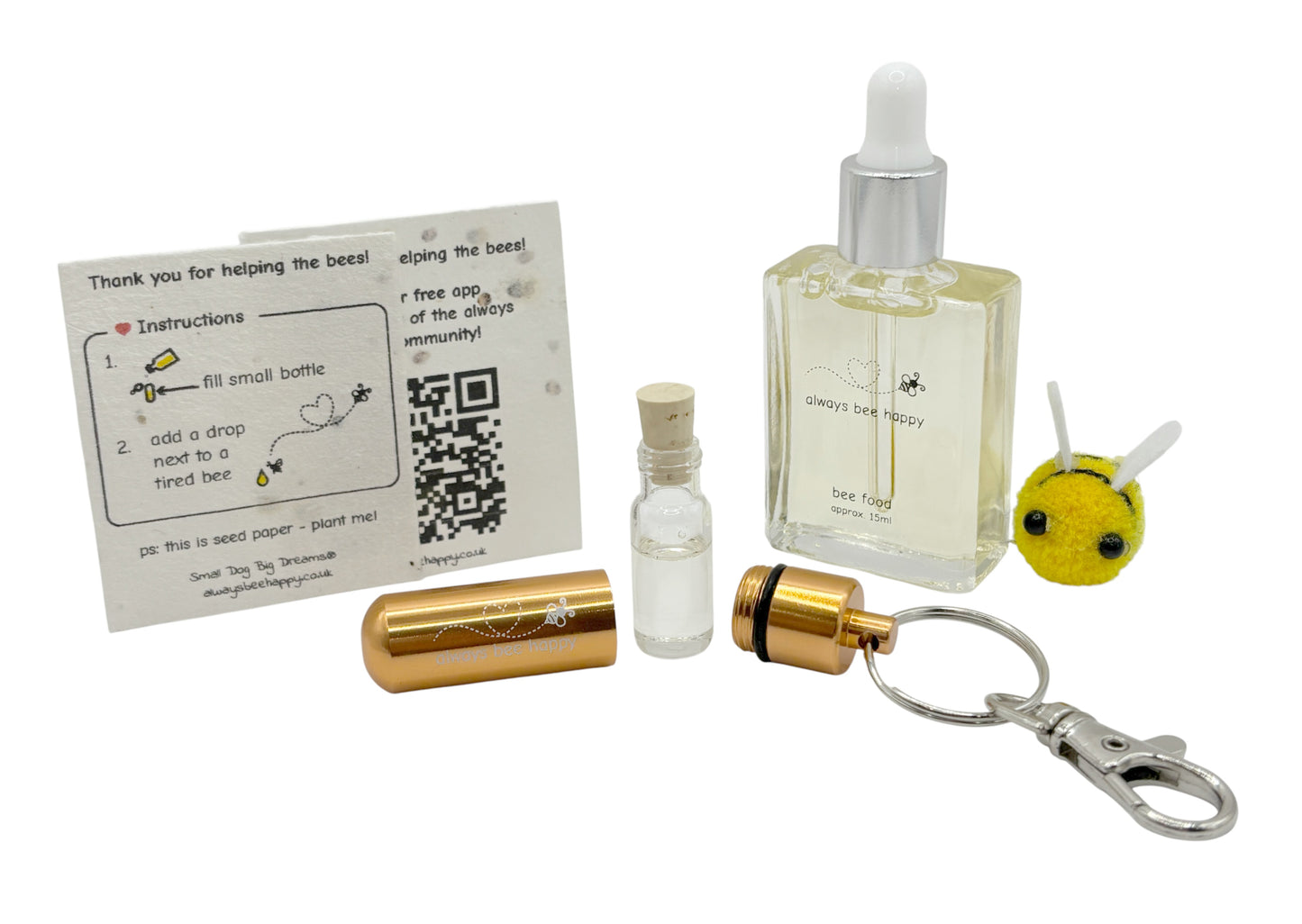 Bee revival kit including a 15ml bottle for top-ups, rose-gold aluminium keychain with inner glass vial and premium cork, and instruction card on seed paper. And a fluffy bee of course.
