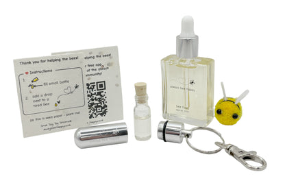 Bee revival kit including a 15ml bottle for top-ups, silver aluminium keychain with inner glass vial and premium cork, and instruction card on seed paper. And a fluffy bee of course.